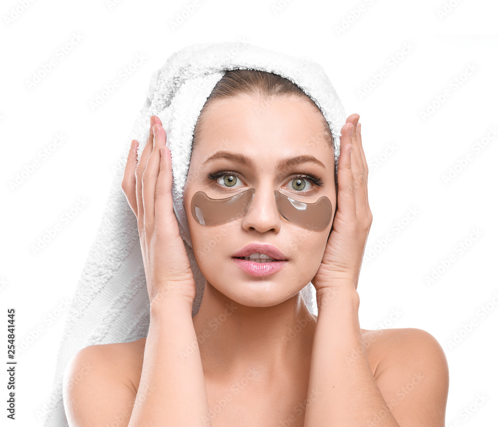 Young woman with under-eye patches on white background