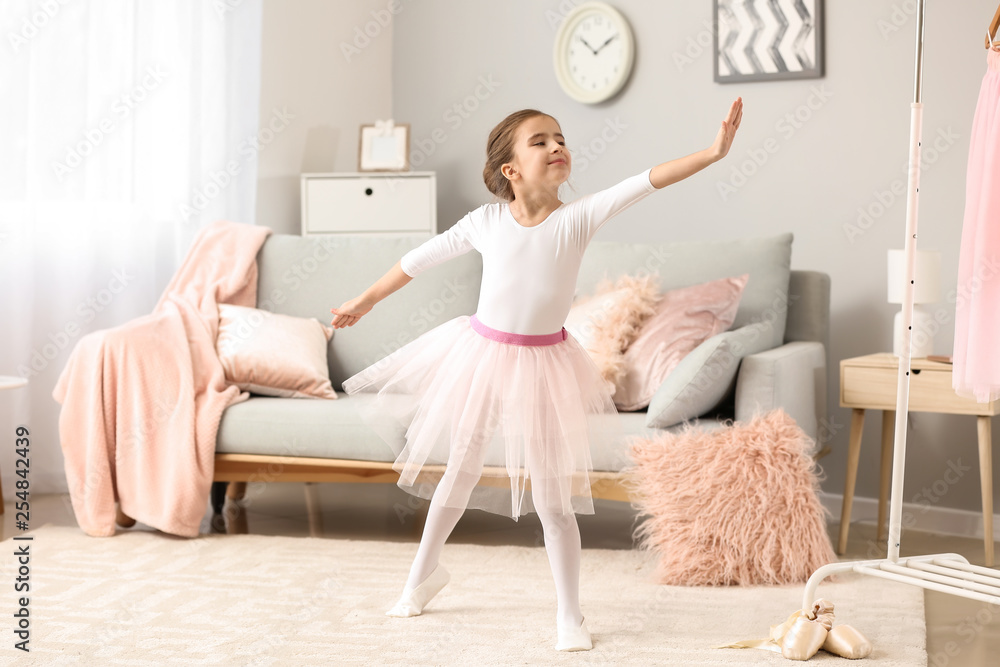 Cute little ballerina dancing at home