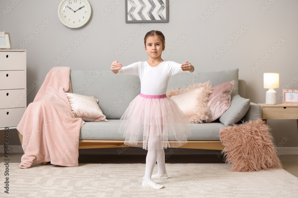 Cute little ballerina dancing at home