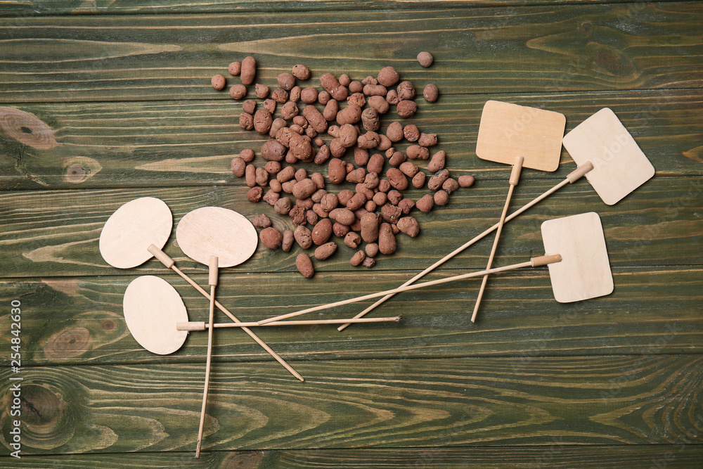 Clay pellets for gardening and blank tags on wooden background