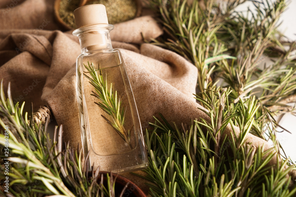 Bottle with rosemary oil on table