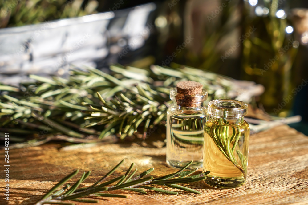 Bottles with rosemary oil on table