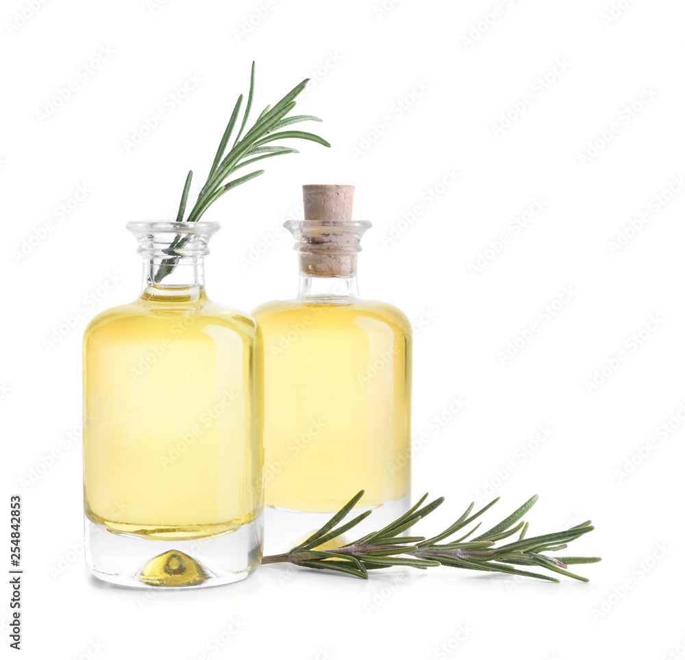 Bottles with rosemary oil on white background