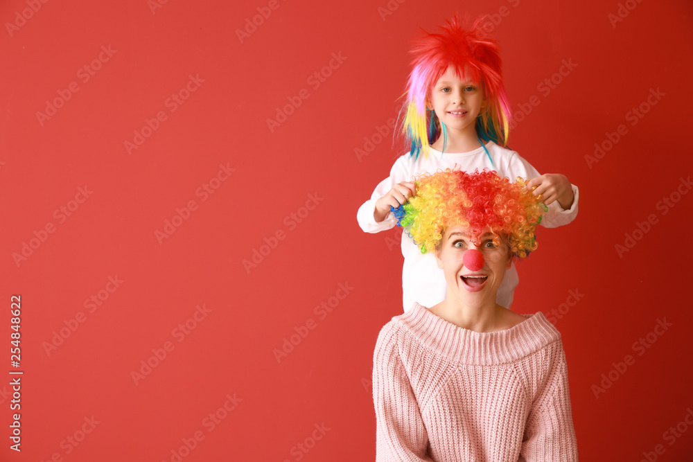 彩色背景上滑稽伪装的女人和小女孩。愚人节庆祝活动