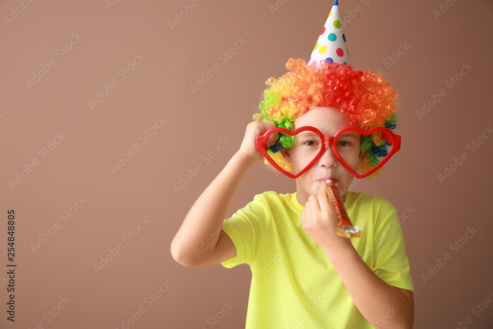 Little boy in funny disguise on color background. April fools day celebration