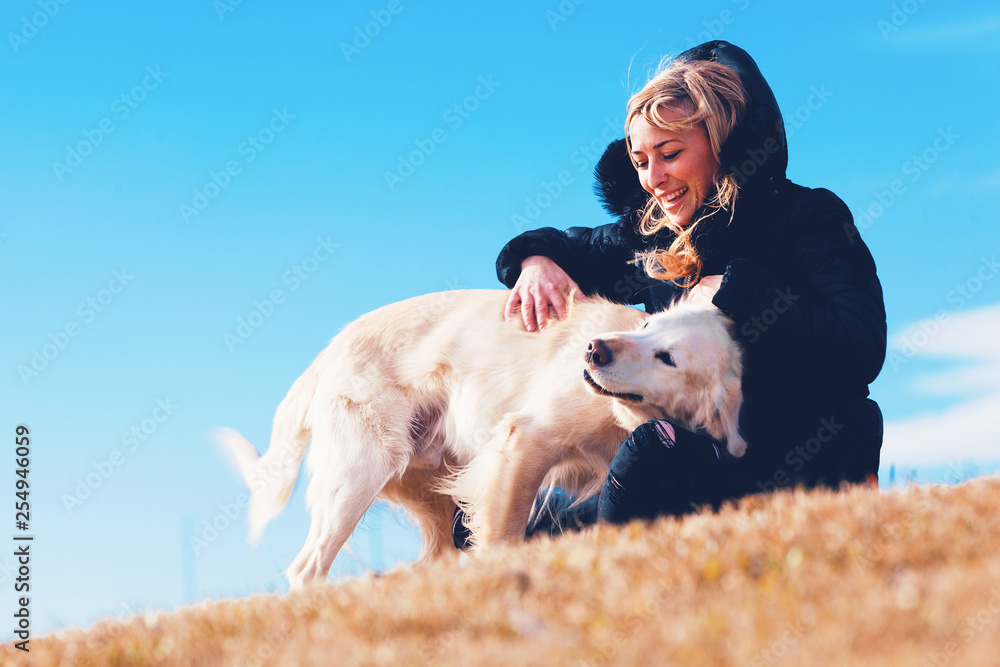 Perros y mascotas.Chica rubia jugando con su perro en el parque