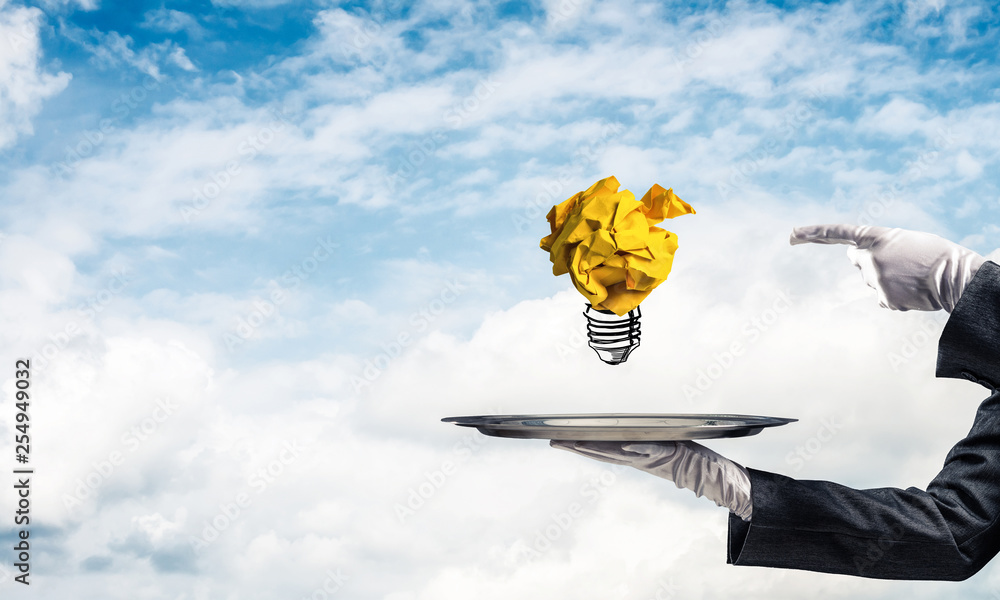 Hand of waiter presenting crampled paper lightbulb