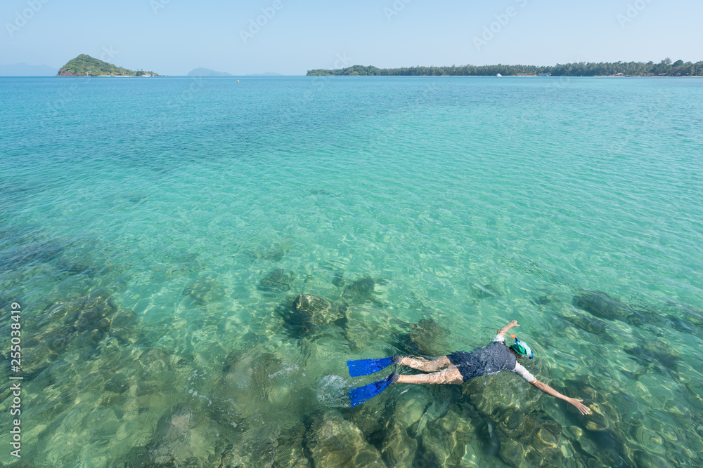 Tourists snorkel in crystal turquoise water near tropical resort in Phuket, Thailand. Summer, Vacati