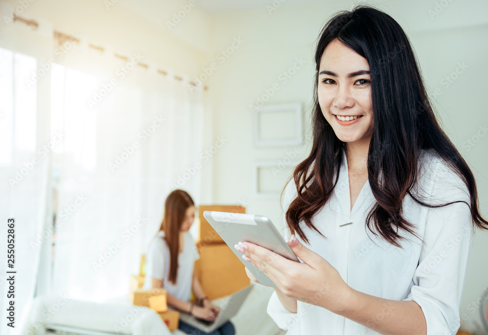 Young asian girl is freelancer with her private business at home office, working with laptop, coffee