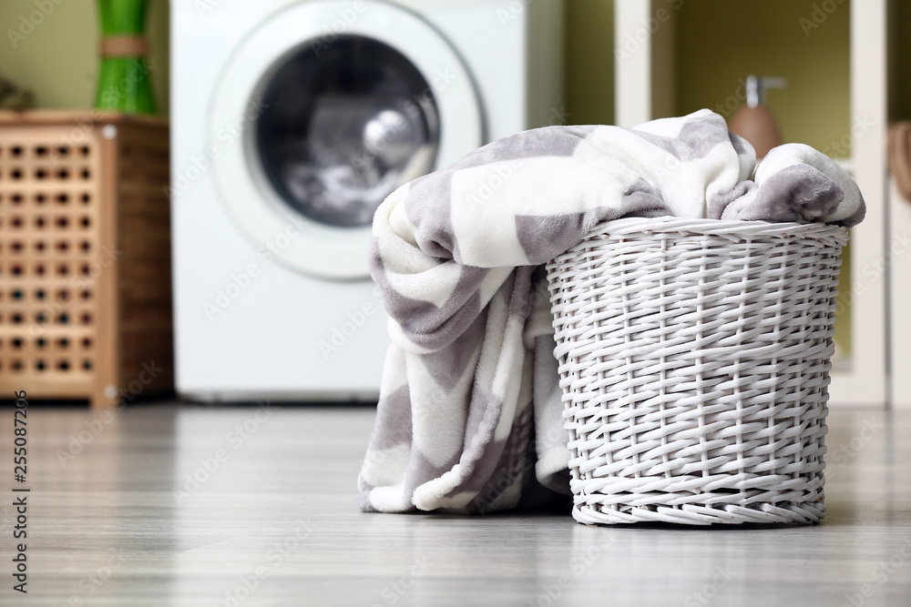 Basket with dirty laundry on floor in bathroom