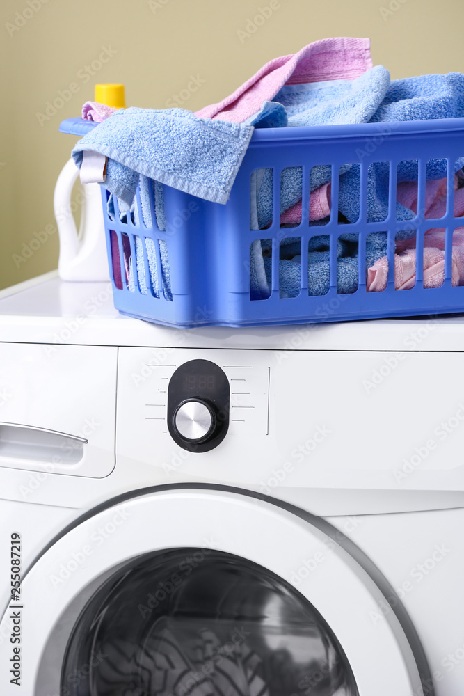 Basket with dirty laundry on washing machine