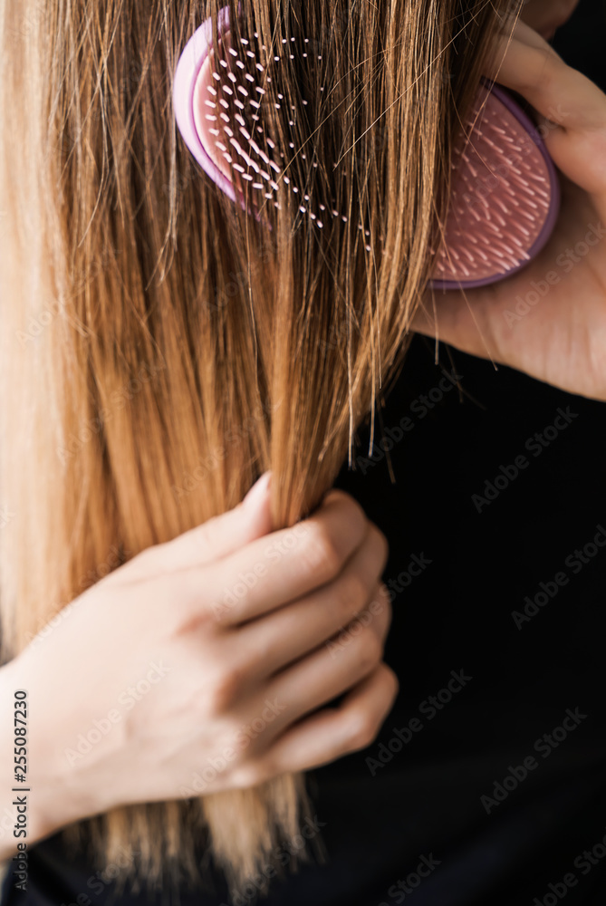 Young woman brushing her long hair