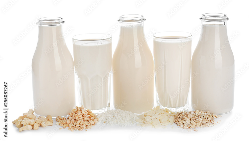 Glassware of different vegan milk on white background