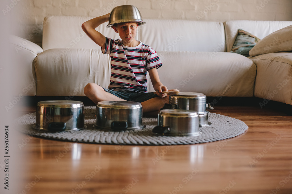 Future drummer boy with cooking pots at home