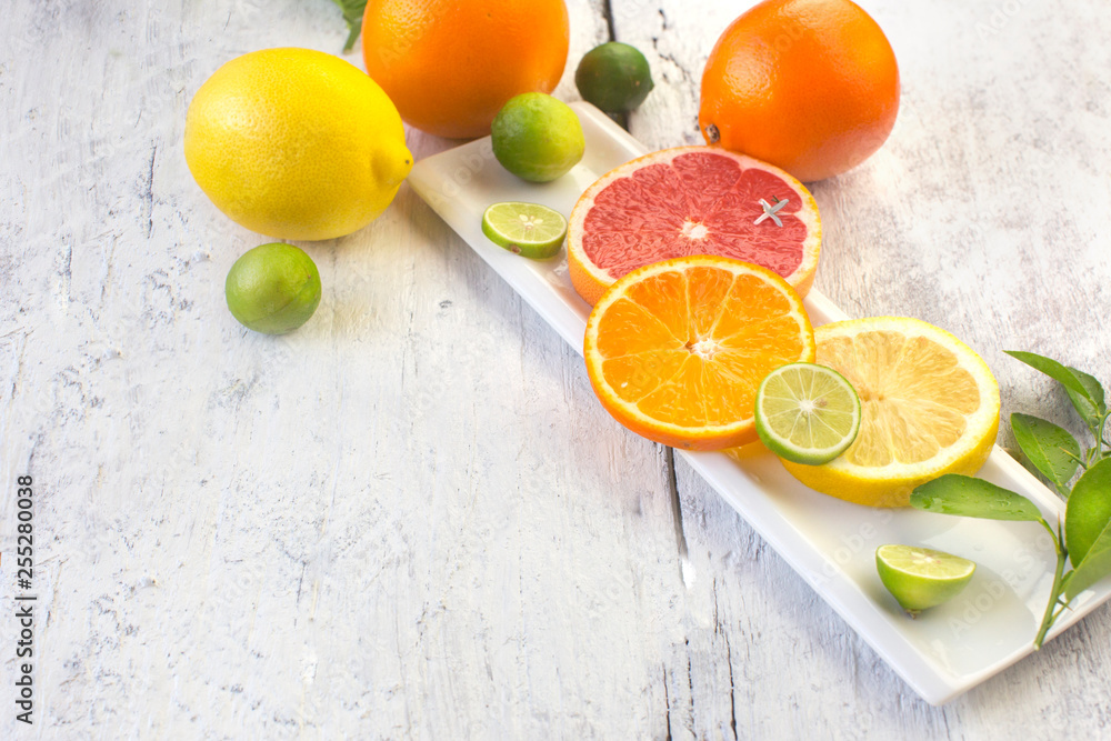 Various citrus fruits slice on white wooden table top.