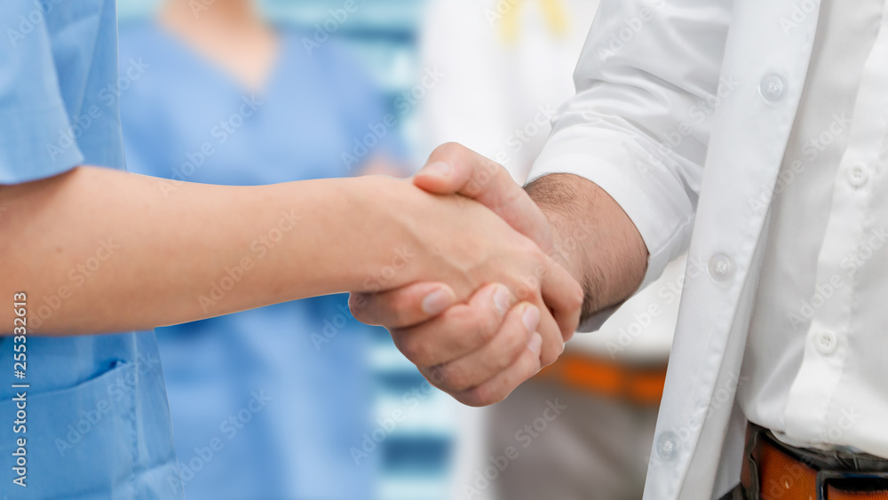 Doctor in hospital handshake with another doctor. Healthcare people teamwork and medical service con