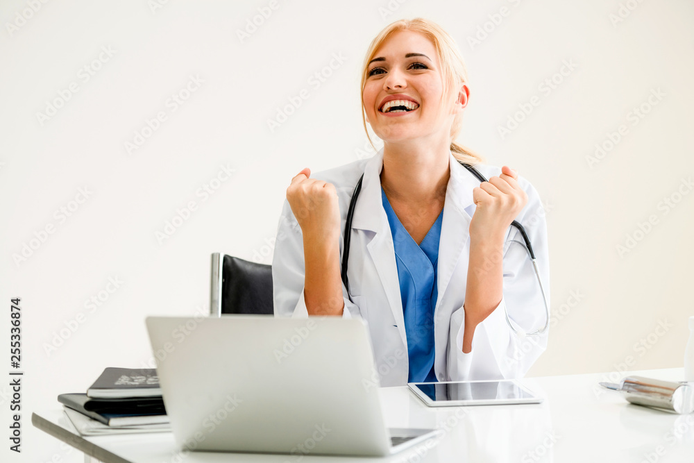 Happy successful woman doctor feels delightful in hospital or healthcare institute while working on 