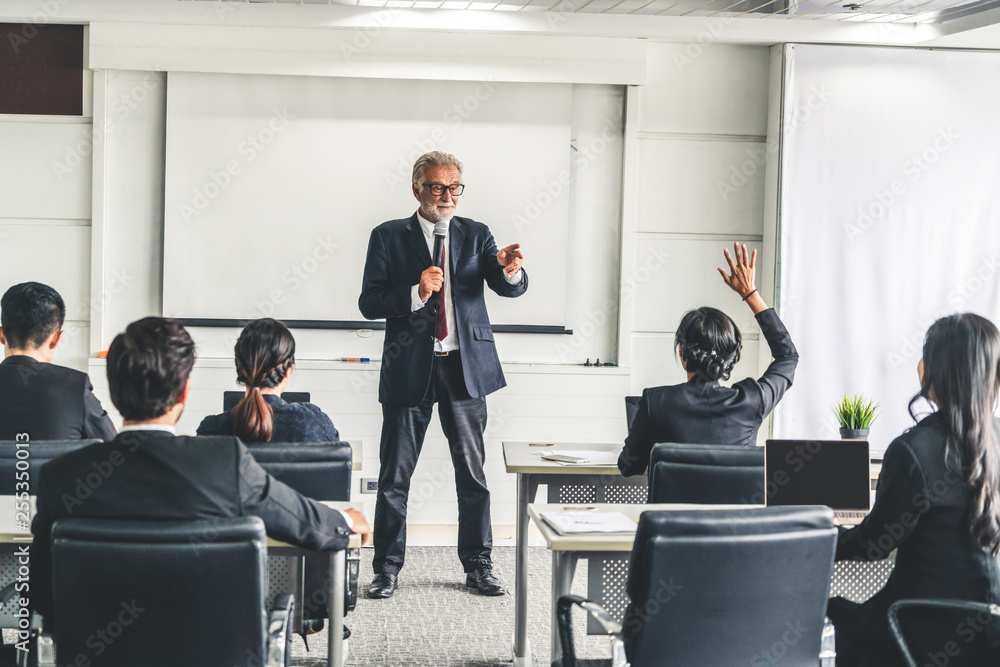 Senior leader speaker speaks to public people audience in training workshop or conference. Mature le