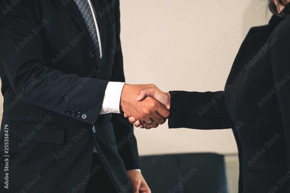 Business people agreement concept. Businessman and Asian businesswoman do handshake in the office.