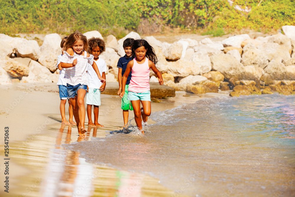 Happy children running on the beach in summer