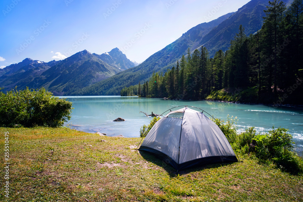 Camping tent in the nature. Mountains and lake