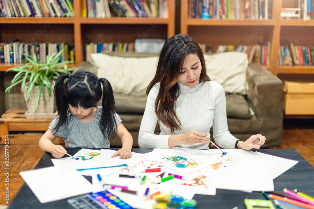 pretty caucasian girl kid enjoy painting crayon color art on paper with mom on sofa background home 