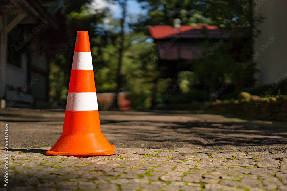 模糊背景下用于在人行道上停车的条纹塑料路标。橙色交通道路