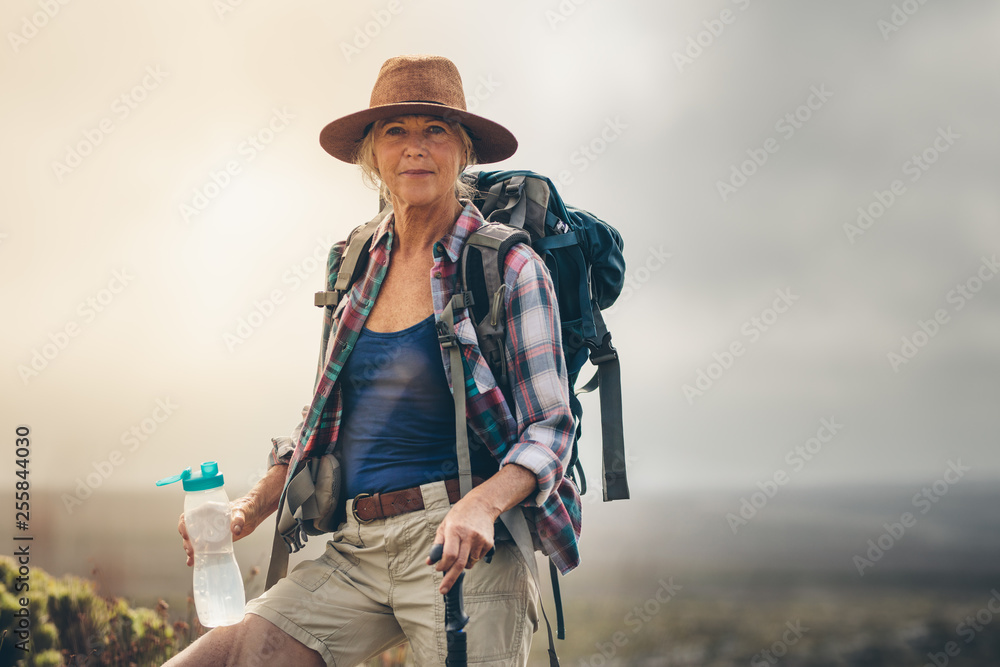 女徒步旅行者在徒步旅行中喝水