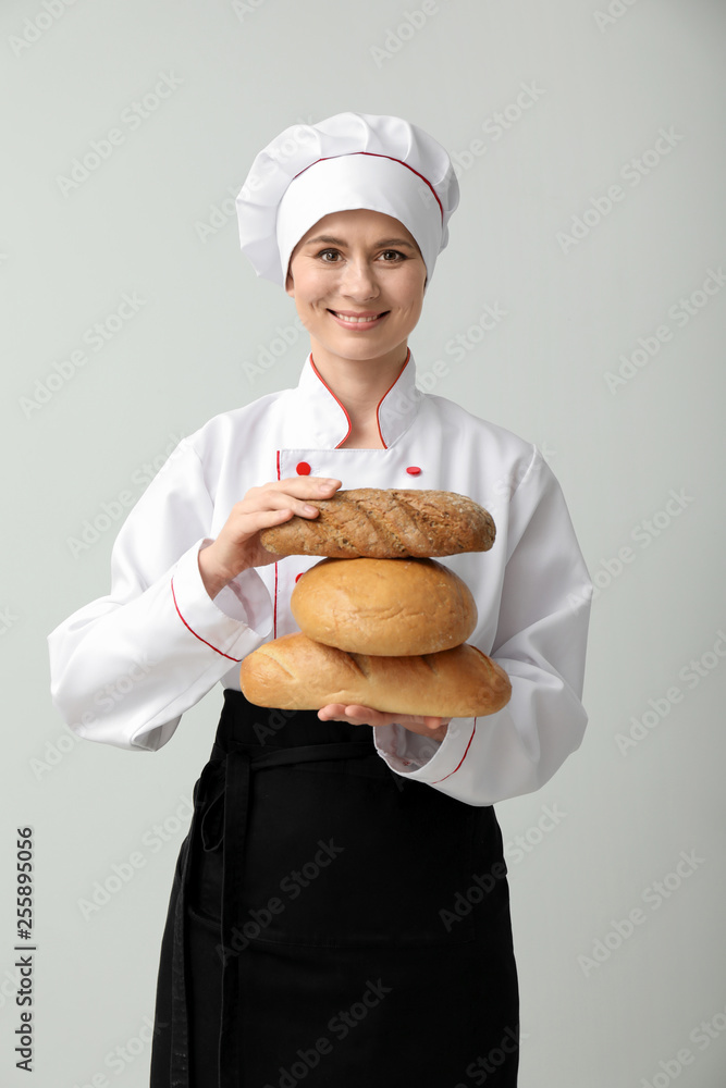 Beautiful female baker on light background