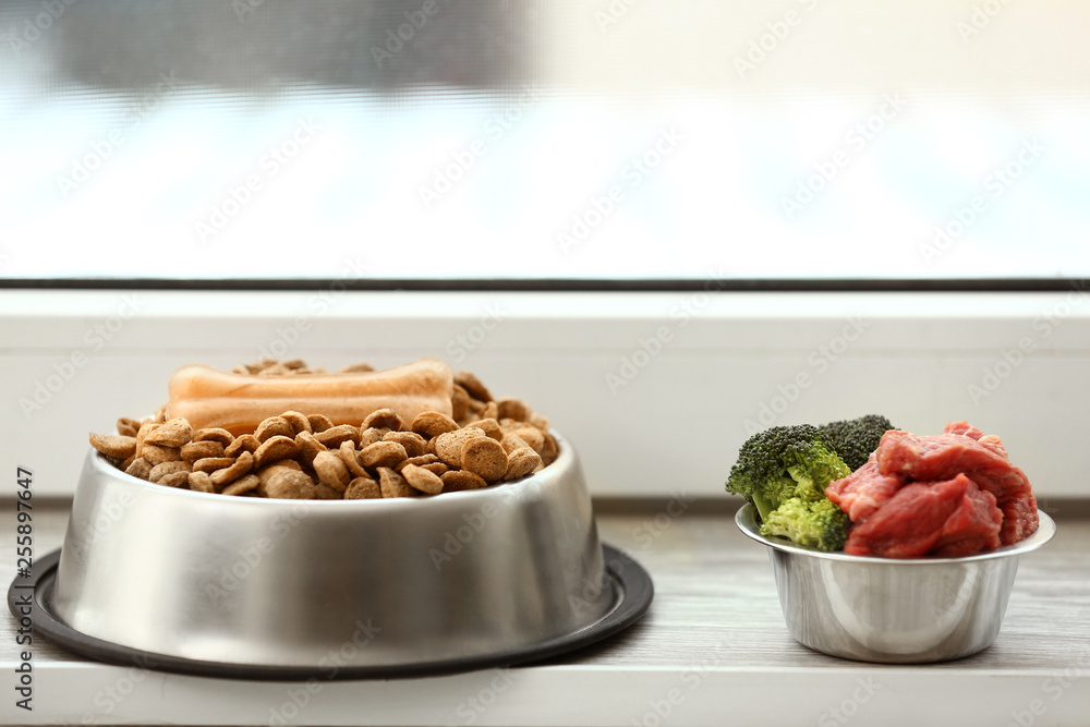 Bowls with dry and fresh pet food on window sill