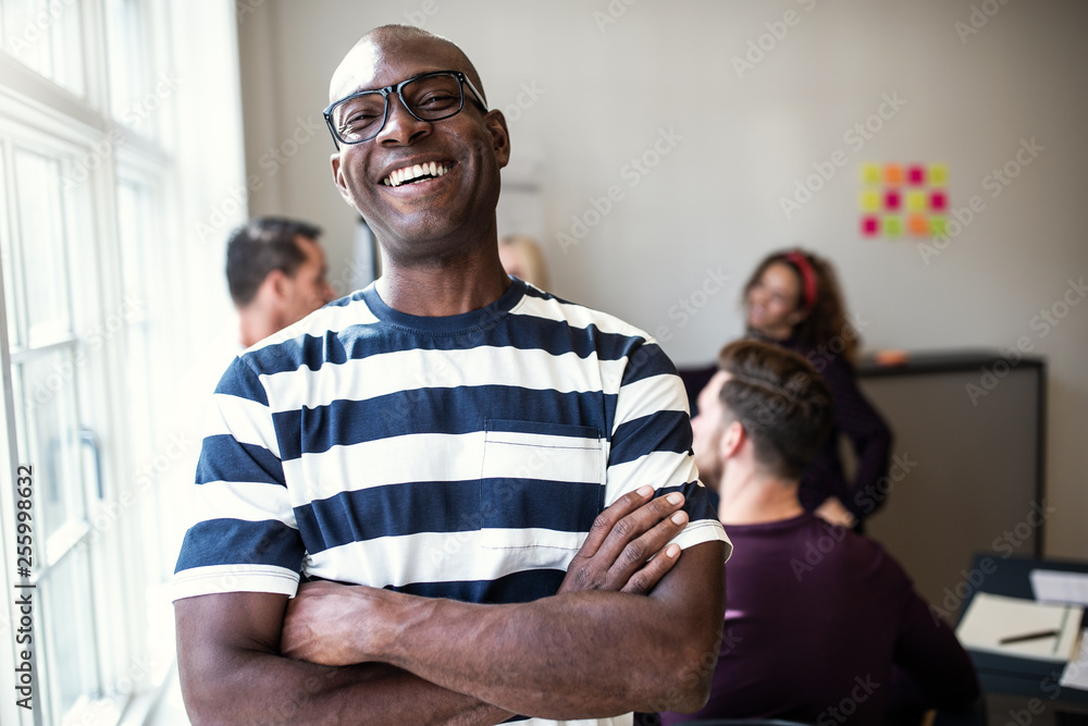 Laughing African designer standing in an office after a meeting