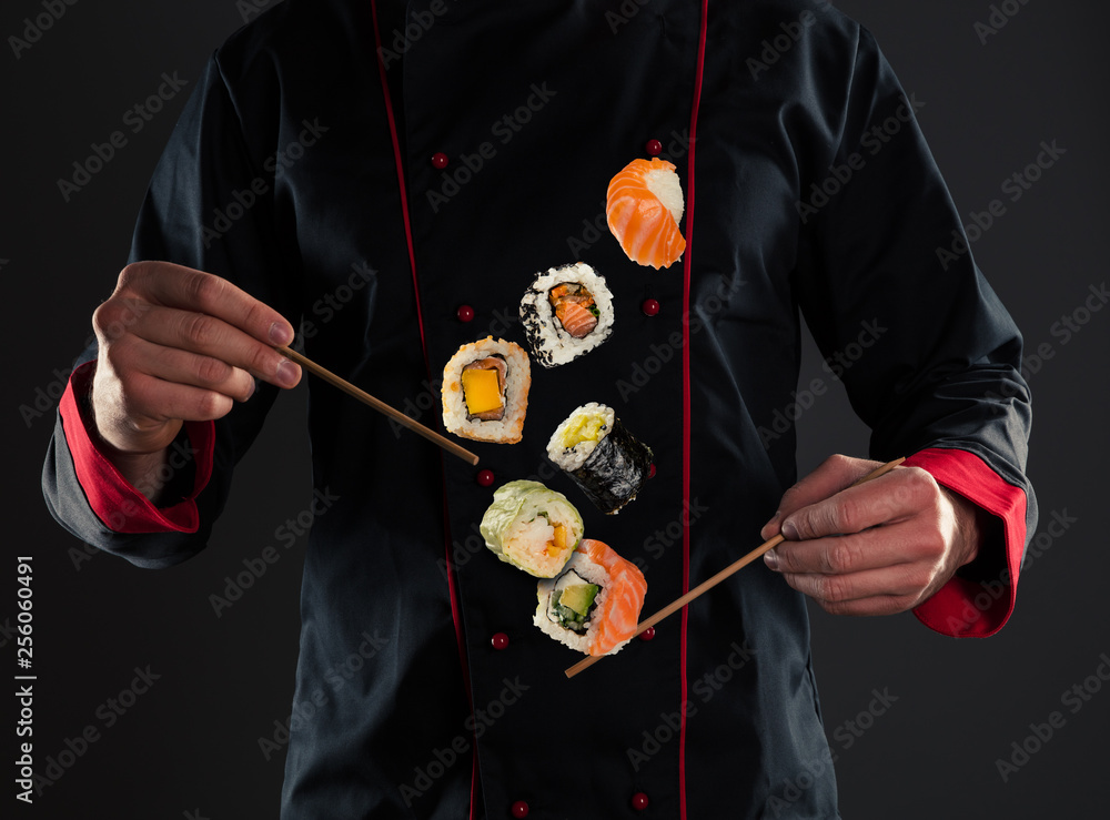 Master chef holding chopsticks with flying sushi