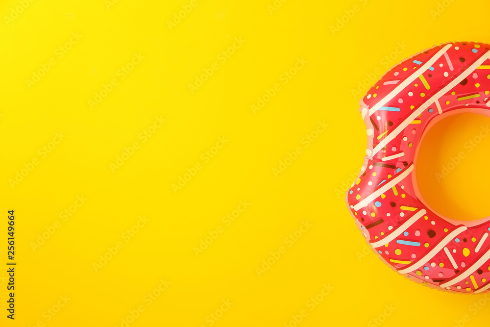 Bright inflatable ring on color background