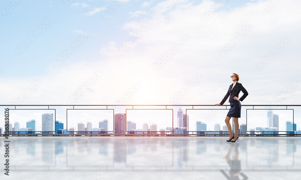 Sunrise above skyscrapers and businesswoman facing new day