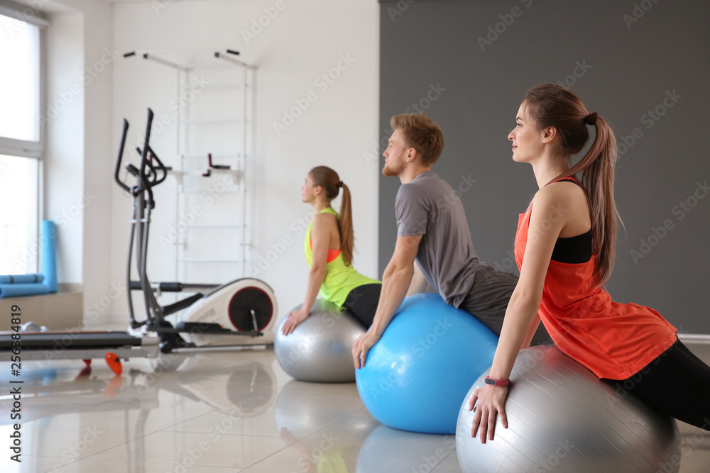 Group of people training with fitballs in gym