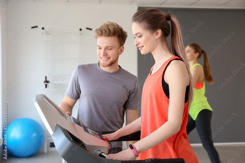 Young woman training with instructor in gym