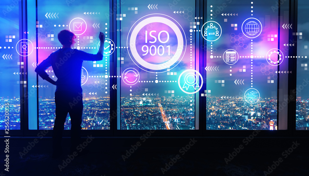 ISO 9001，晚上，一个人在一个庞大的城市上空的大窗户上写字