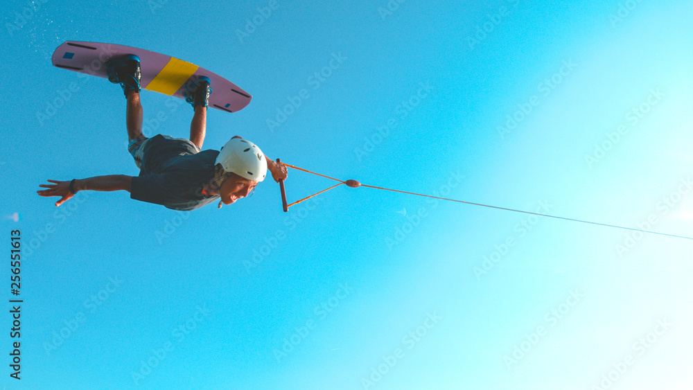 SUN FLARE: Awesome wakesurfer flies across the sunny sky and does a spin trick.