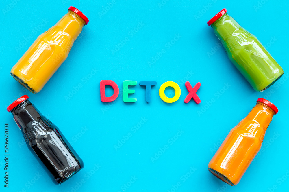 healthy organic juice in bottles for fitness diet and detox on blue background top view mockup