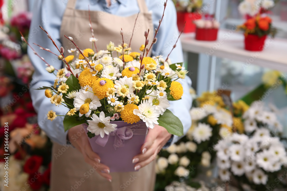 Female owner with beautiful flowers in shop