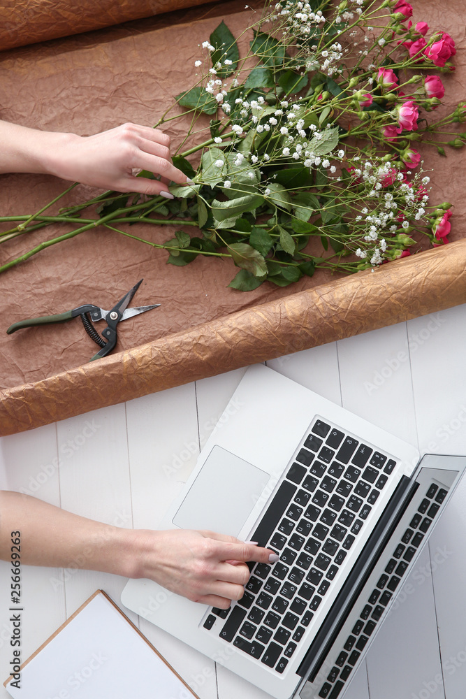 Female florist working at white table