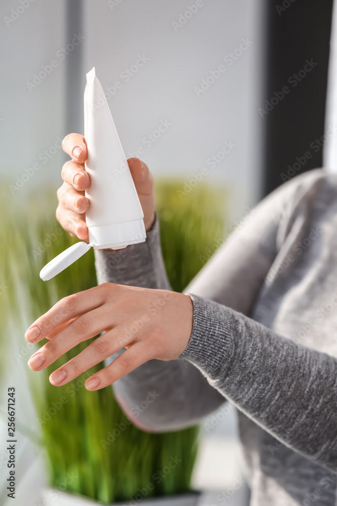 Woman applying natural cream onto skin, closeup