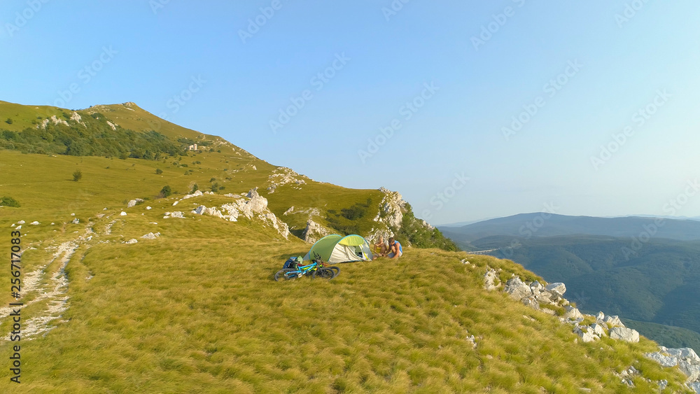 无人机：一对活跃的夫妇在山地自行车冒险期间准备露营地。