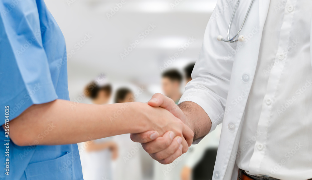 Doctor in hospital handshake with another doctor. Healthcare people teamwork and medical service con