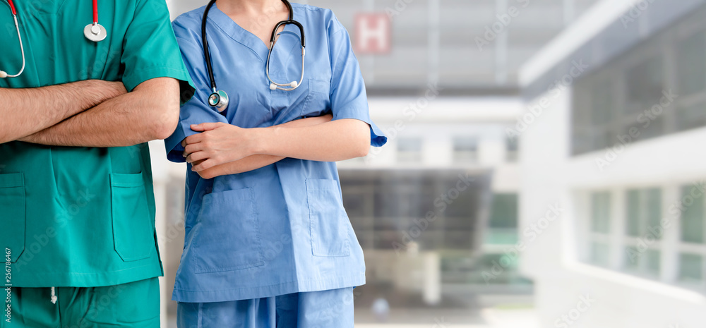 Two hospital staffs - surgeon, doctor or nurse standing with arms crossed in the hospital. Medical h