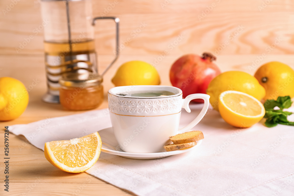 Cup of hot tea with lemon and ginger on table