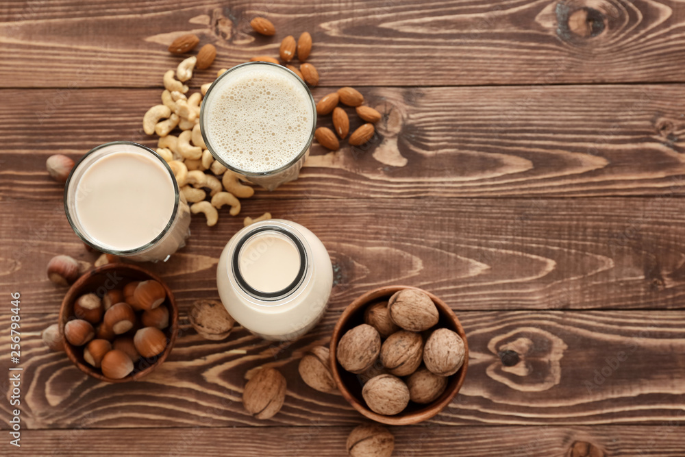 Assortment of tasty vegan milk on wooden table