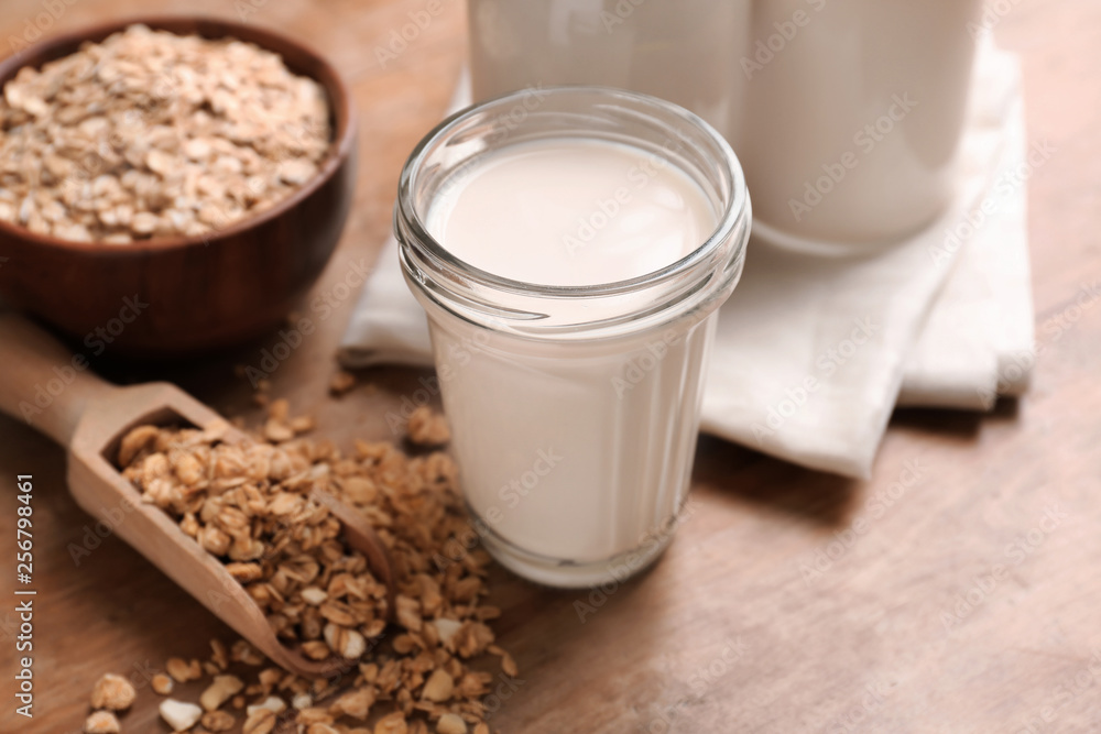 Tasty oat milk on wooden table