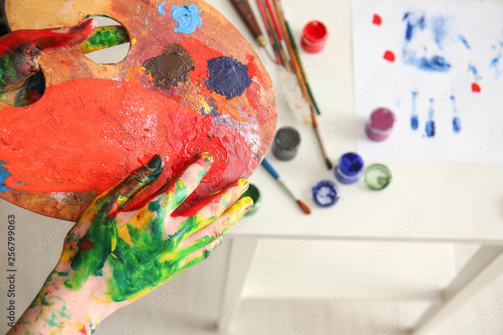 Female artist with paint palette in studio, closeup