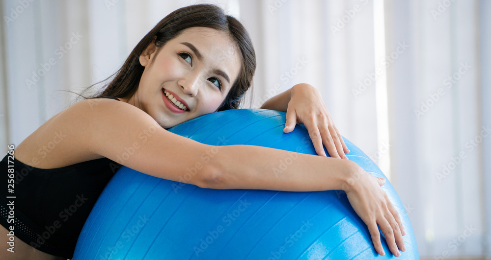 Beautiful young woman in fitness center doing pilates exercise with fitness ball. Healthy lifestyle 